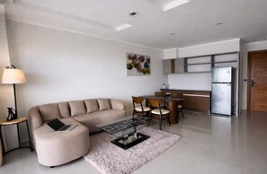 A modern living room with a sofa, a coffee table, and a dining area with chairs. - Chalong Miracle Lakeview 4021 (Chalong)