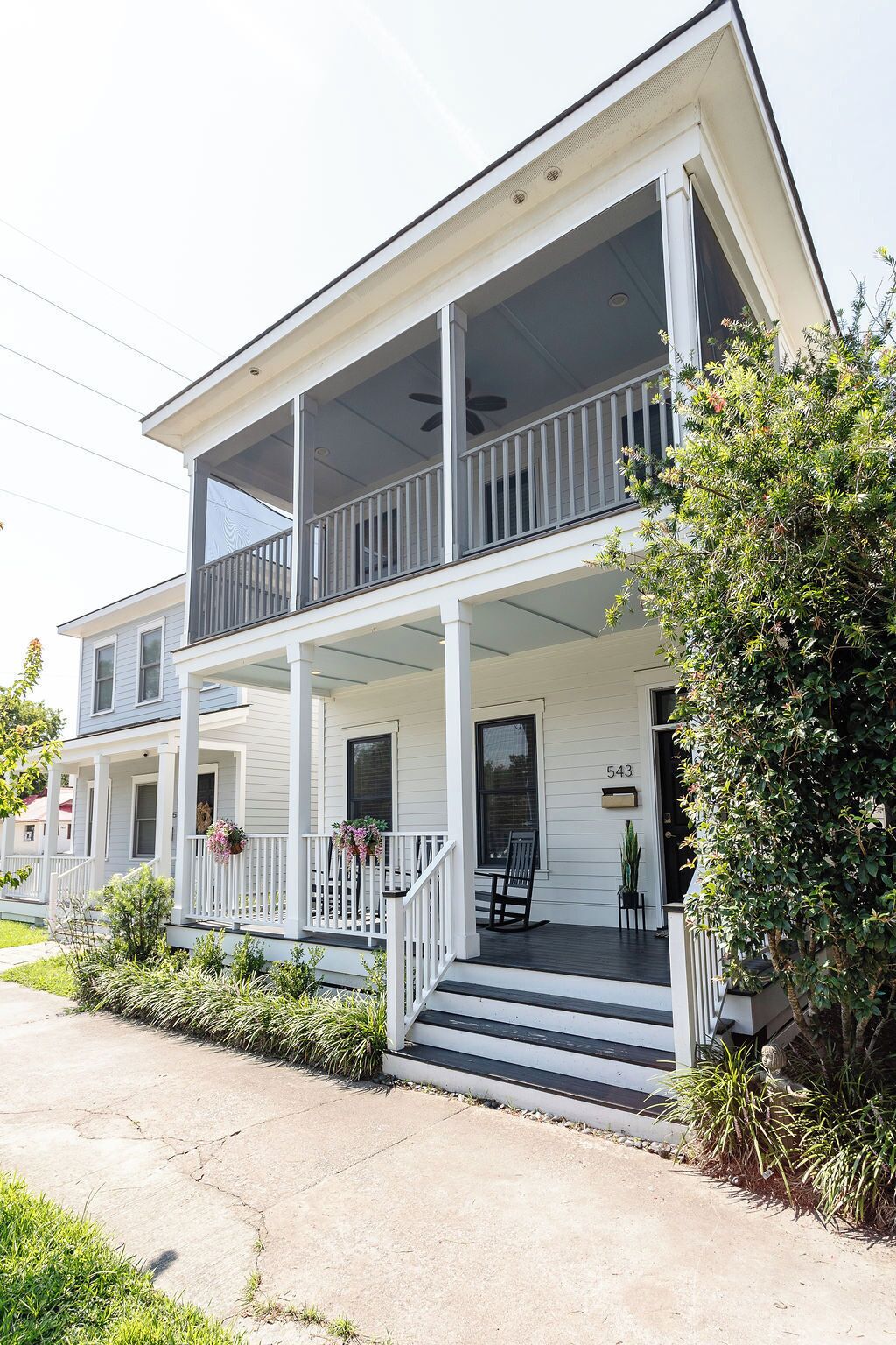 A two-story house with a porch, a front door, and a mailbox.