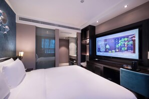 A modern hotel room with a large bed, a flat-screen TV, a desk, and a bathroom visible through a sliding door. - Crystal orange chengdu KuanZhai Alley (Chengdu)