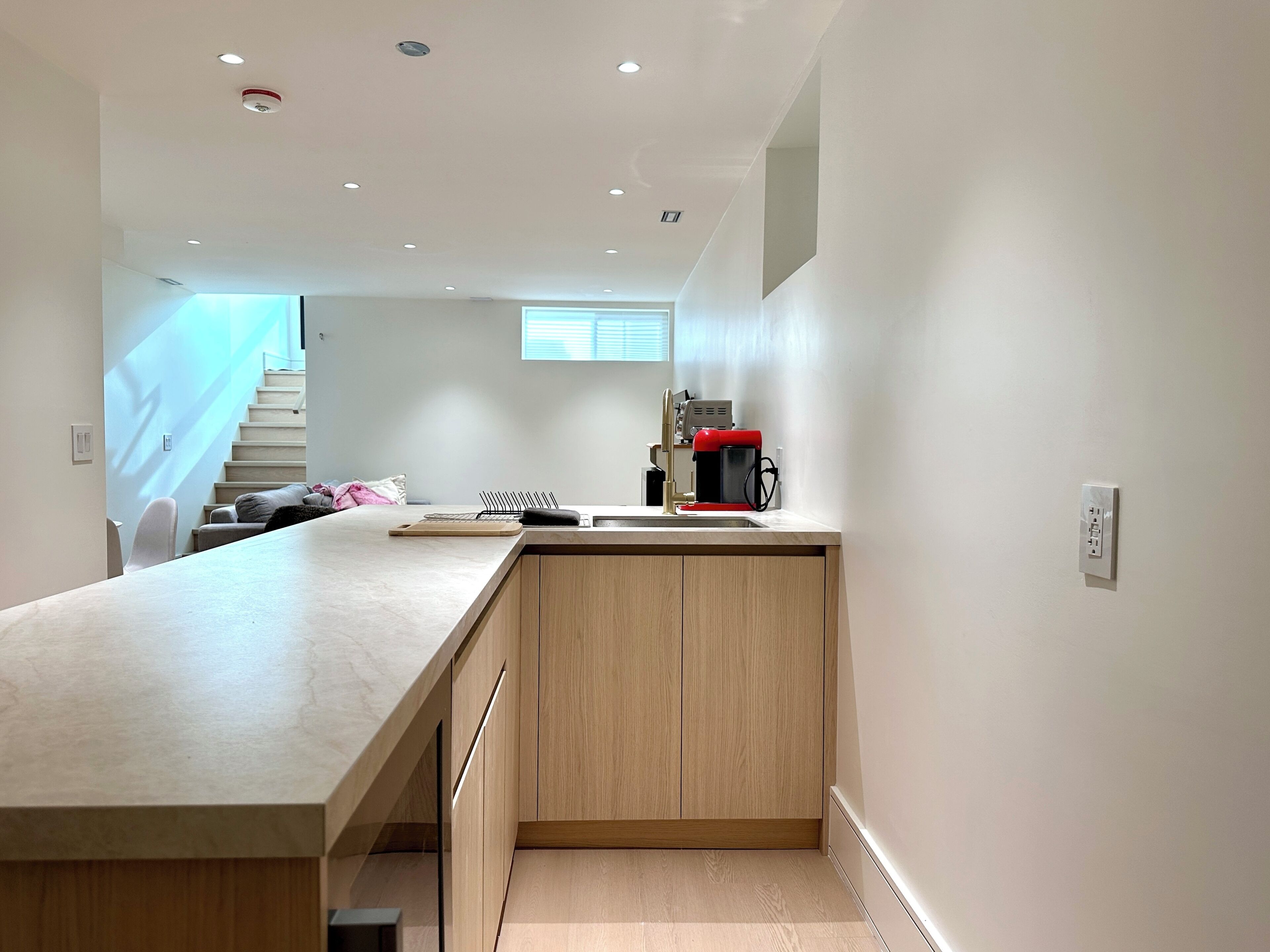 A modern kitchen with a wooden countertop, a coffee machine, and a built-in sink.