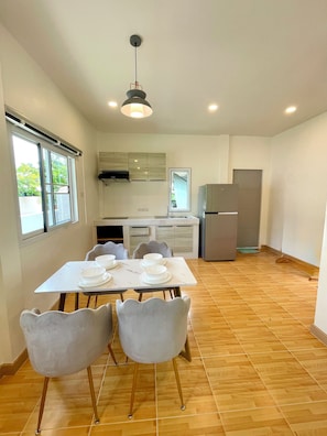 A modern kitchen with white cabinets, a built-in oven, and a refrigerator. - Harmonia Residence Naiharn Phuket (Rawai)
