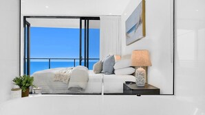 Ein modernes Schlafzimmer mit einem großen Fenster, einem Bett, einem Nachttisch mit Lampe und einer kleinen Pflanze.
