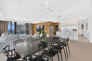 A modern living room with a dining area, a kitchen, and a balcony with a view. - Mega Ocean View Skyhome at Oracle Level 37 (Gold Coast)