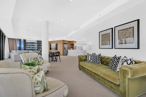 A modern living room with a sofa, chairs, a dining area, and artwork on the walls. - Mega Ocean View Skyhome at Oracle Level 37 (Gold Coast)
