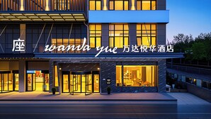 Une façade d’hôtel moderne, dotée d’une enseigne lumineuse et de grandes fenêtres.