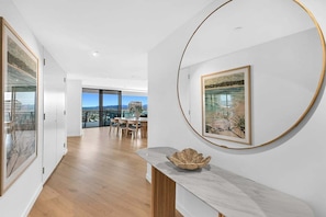 Ein modernes Interieur mit Essbereich, Kunstwerken an den Wänden und Blick durch die Glastür.