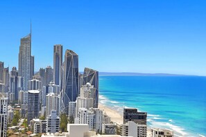 Eine Küstenstadt mit Hochhäusern, einem Strand und blauem Himmel.