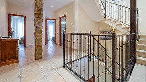 Ein geräumiger Innenraum mit Treppe, Steinpfeiler und Blick auf die Stadt.