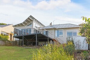 A residential property with a covered outdoor area, a sloped roof, and a fenced yard.