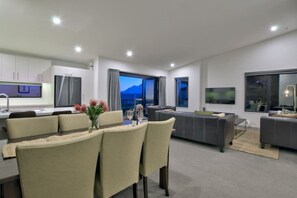 Una sala de estar moderna con comedor, un sofá y un televisor.