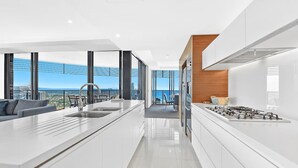 Une cuisine moderne dotée d’un îlot central, d’une cuisinière et offrant une vue sur la ville.