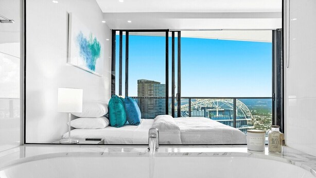 Une chambre moderne avec une grande fenêtre, une baignoire et une vue sur une grande roue.