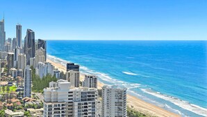 Un paysage urbain côtier avec de hauts immeubles, une plage et l’océan.