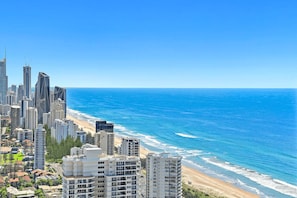 Eine Küstenstadt mit Hochhäusern, einem Strand und dem Meer.