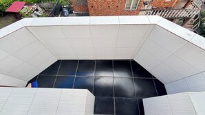 A room with a tiled floor, a white ceiling, and a brick wall. -  Home Away From Home: Bright Quiet Fully Equipped Self Check-In Central Location (Râmnicu Vâlcea)