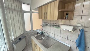A kitchen with a sink, cabinets, and a window. -  Home Away From Home: Bright Quiet Fully Equipped Self Check-In Central Location (Râmnicu Vâlcea)