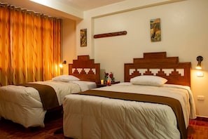 A hotel room with two beds, wooden headboards, a nightstand with a vase of flowers, and wall-mounted artwork.