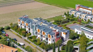 A modern residential complex with multiple apartment buildings, a central courtyard, and surrounding greenery. - Garda Therme Apartment With Balcony & Mountain Views (Arco)