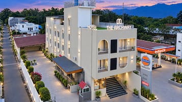 Hotel com design moderno, apresentando uma estrutura em dois andares, entrada coberta e escadaria visível para o acesso.
