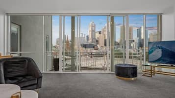 Departamento Deluxe, balcón, vista a la ciudad | Área de sala de estar | Smart TV