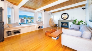 Un salon chaleureux avec un plafond en bois, un canapé, un banc et une cheminée.