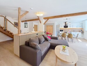 A modern living room with a sectional sofa, a dining area, and a kitchen. - Halbeis by Interhome (Matrei am Brenner)