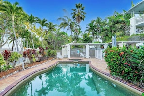 A pool surrounded by tropical plants and a white fence. - Oceanfront Gem at Trinity Beach - Pool - Sea View (Trinity Beach)