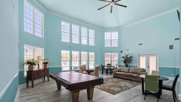 A spacious room with a pool table, a sofa, and a dining area. - Gulf Shores Condo with Pool & Hot Tub (Gulf Shores)