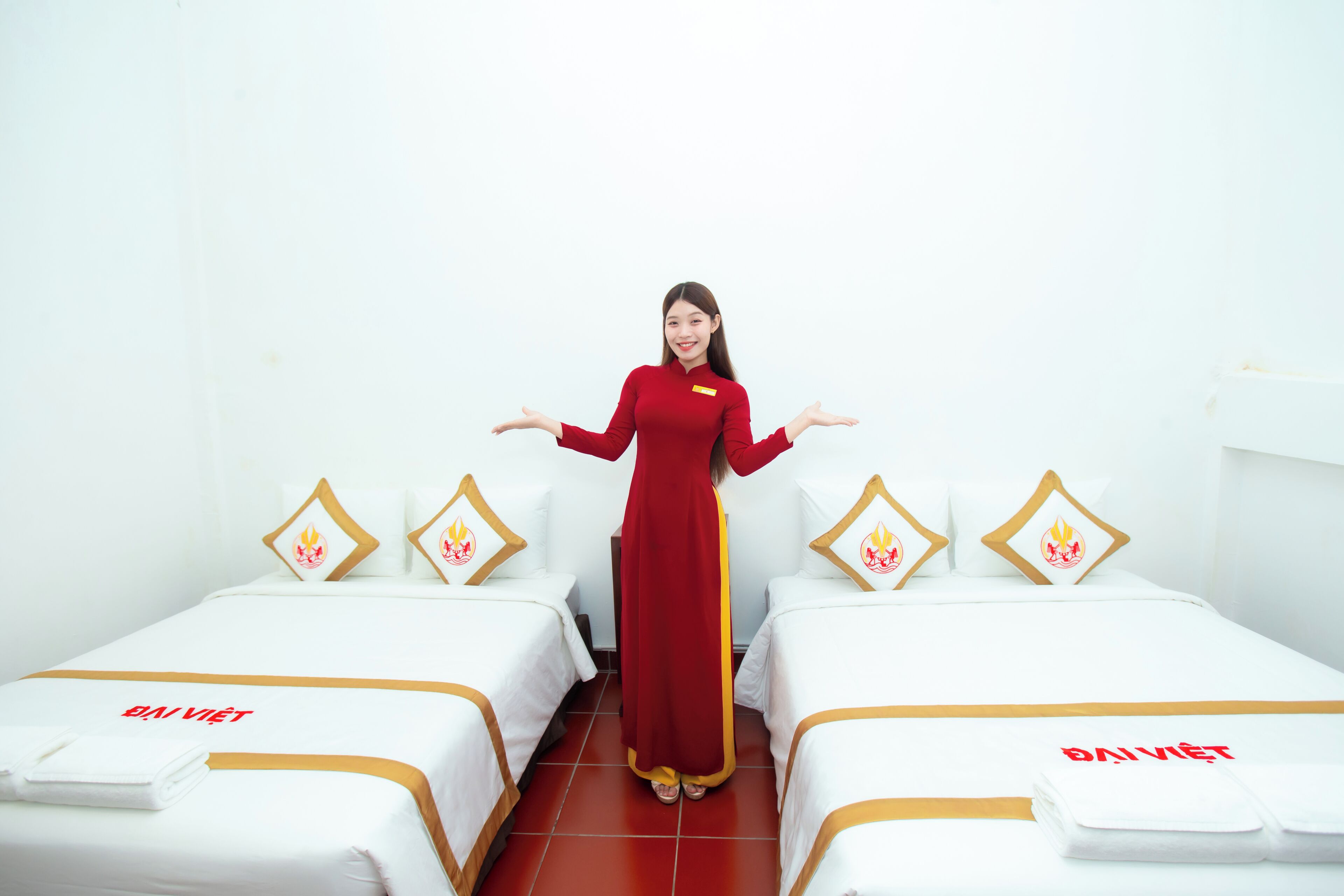 A hotel room with two beds, each with a white bedspread and a red name tag.