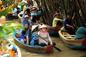 A group of people in traditional boats on a river. - The Rice Hotel & Tour - 27 Nguyen Thai Binh (Ho Chi Minh City)