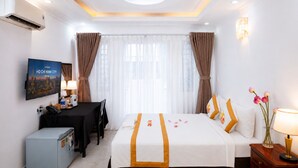 A hotel room with a bed, desk, chair, and a television displaying a cityscape. - The Rice Hotel & Tour - 27 Nguyen Thai Binh (Ho Chi Minh City)