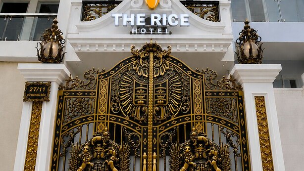 A hotel with a large ornate gate, balconies, and signs for 'DAI VIET RESTAURANT' and 'THE RICE HOTEL'. - The Rice Hotel & Tour - 27 Nguyen Thai Binh (Ho Chi Minh City)