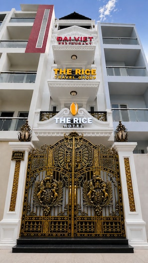 A hotel with a large ornate gate, balconies, and signs for 'DAI VIET RESTAURANT' and 'THE RICE HOTEL'. - The Rice Hotel & Tour - 27 Nguyen Thai Binh (Ho Chi Minh City)