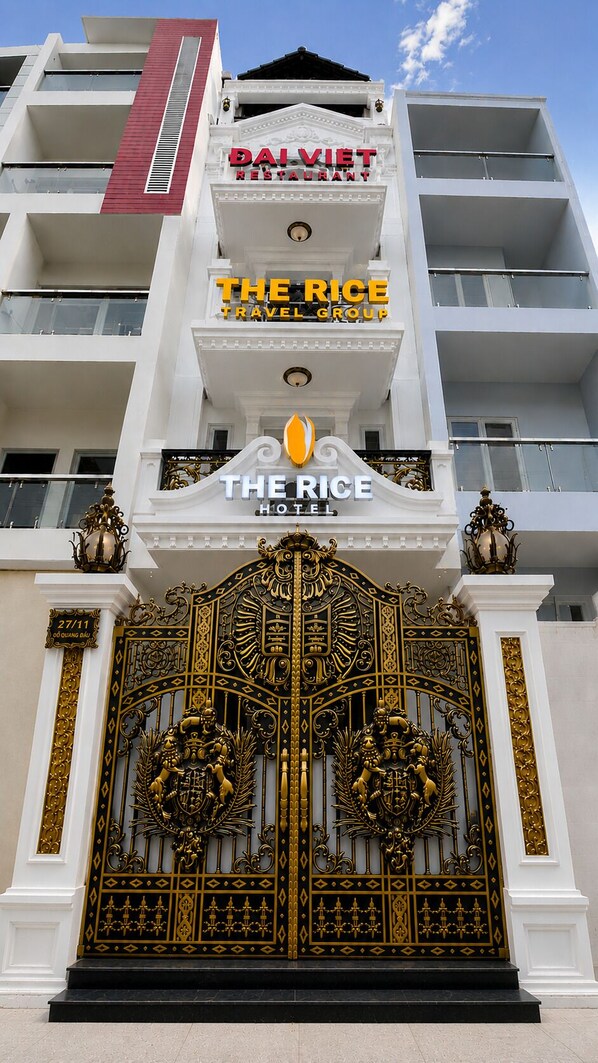 A hotel with a large ornate gate, balconies, and signs for 'DAI VIET RESTAURANT' and 'THE RICE HOTEL'. - The Rice Hotel & Tour - 27 Nguyen Thai Binh (Ho Chi Minh City)