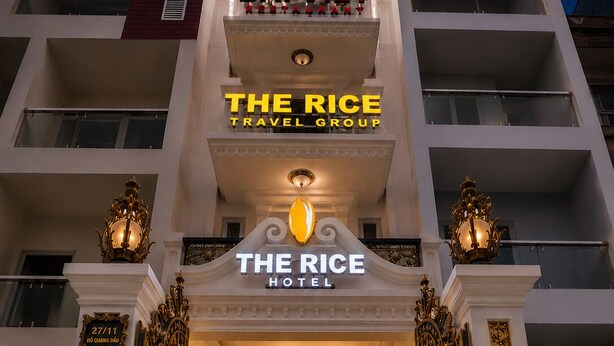 The entrance of The Rice Hotel with a reception desk, a chandelier, and ornate golden gates. - The Rice Hotel & Tour - 27 Nguyen Thai Binh (Ho Chi Minh City)