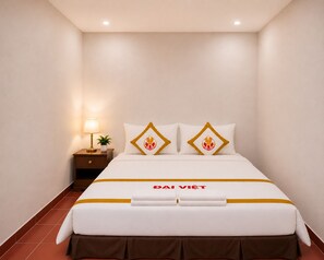 A hotel room with a bed, a nightstand, a lamp, and a small plant. - The Rice Hotel & Tour - 27 Nguyen Thai Binh (Ho Chi Minh City)