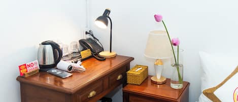 A wooden desk with a kettle, a lamp, a phone, and a 'No Smoking' sign.