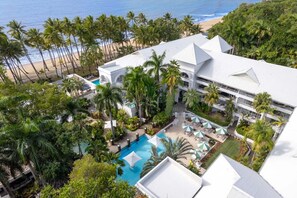 Ein Resort mit Pool, Palmen und Blick auf den Strand.
