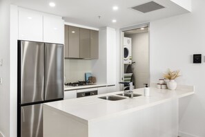 Eine moderne Küche mit einem Edelstahlkühlschrank, einem Einbauofen und einer Spüle.