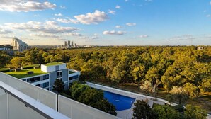 Ein modernes Gebäude mit Pool auf dem Dach und Blick auf eine Stadtlandschaft.