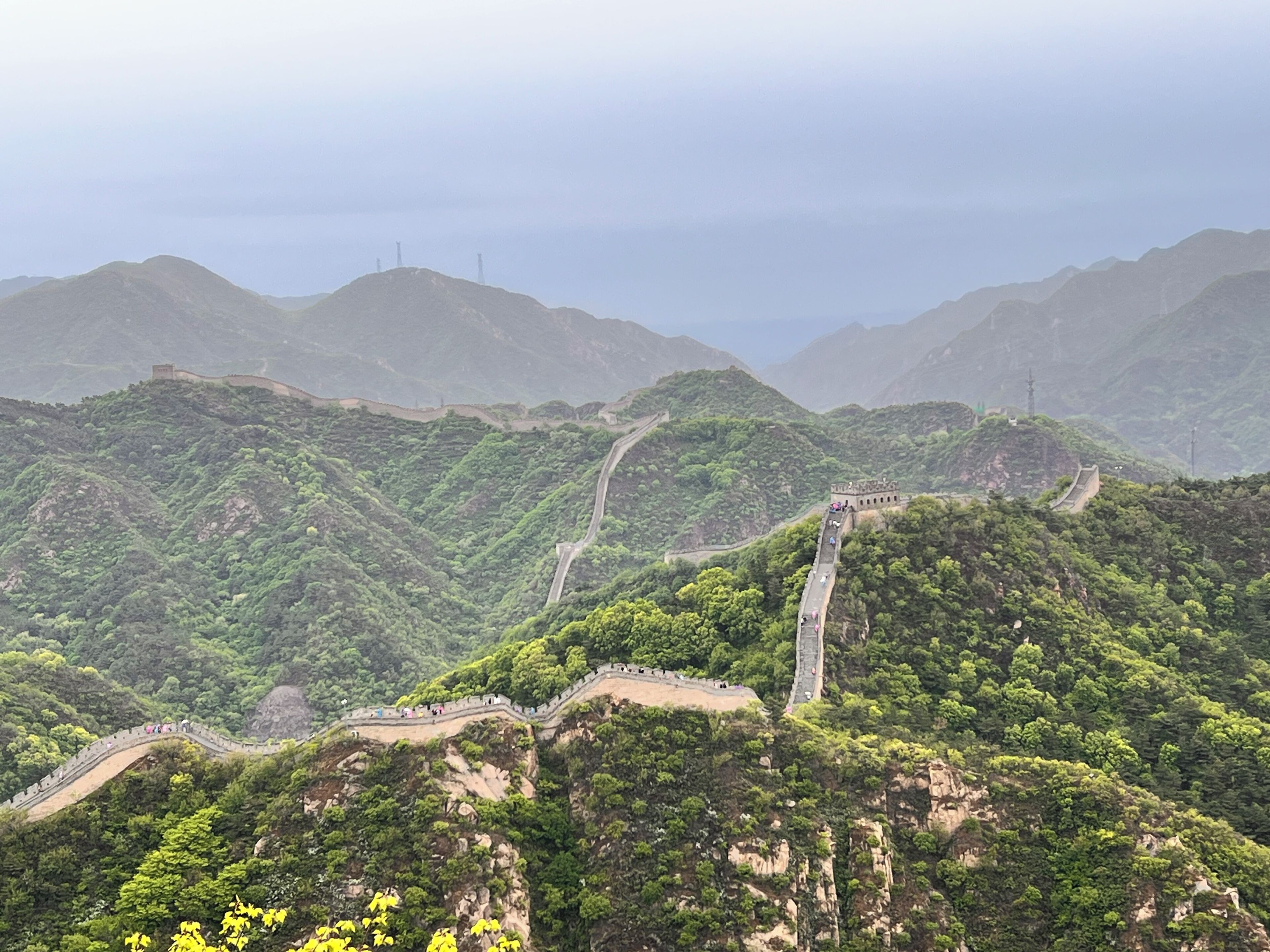 A mountainous landscape with a winding road and a stone wall.
