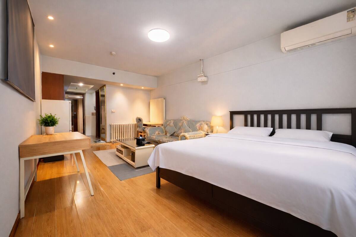 Una habitación de hotel moderna con cama, escritorio y zona de estar.