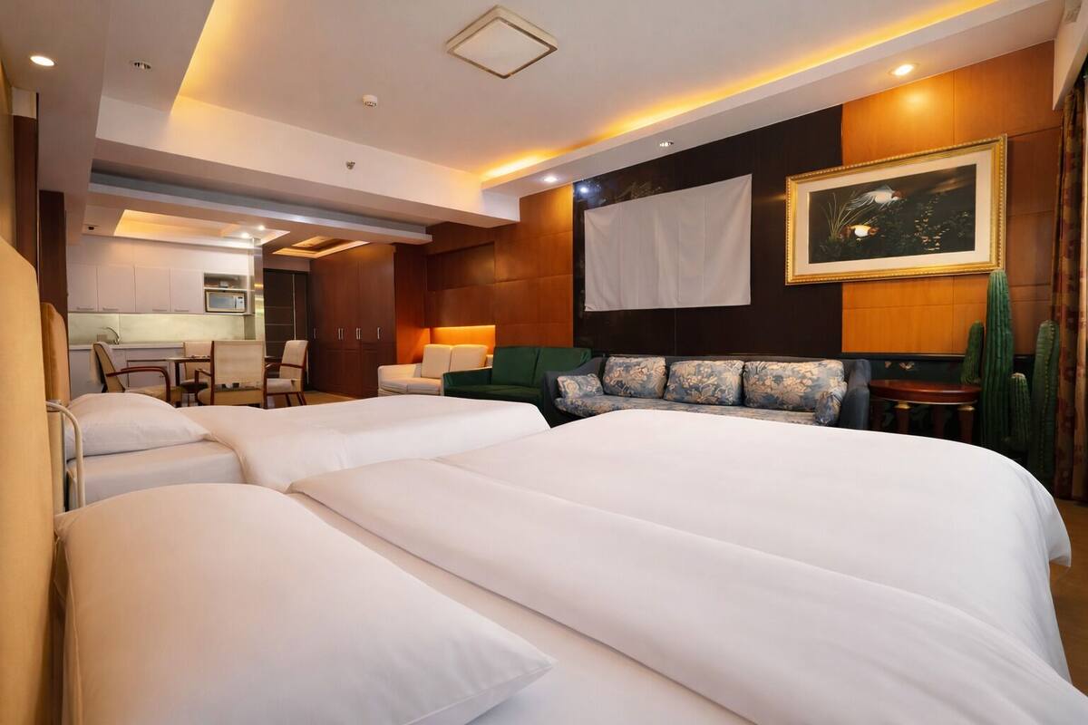 Una habitación de hotel con una cama grande, un sofá, un escritorio y una silla.