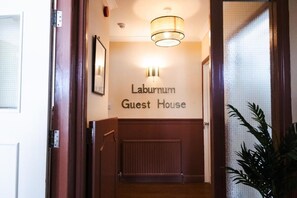 A hallway with a sign reading 'Laburnum Guest House.'