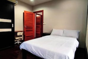 Un dormitorio con cama, escritorio y armario.