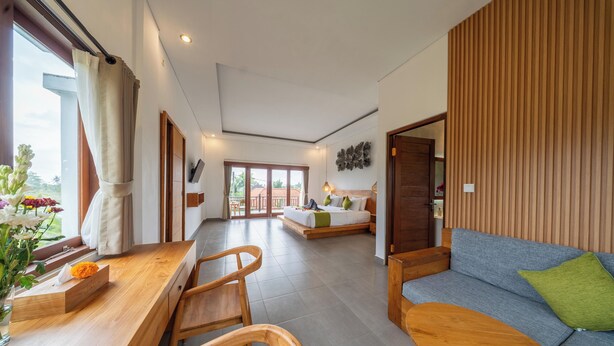 A spacious room with a wooden dining table, a sofa, and a bed with a view of the outdoors. - Ada Private Villa Ubud (Ubud)