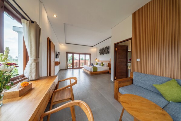 Una habitación amplia con una mesa de comedor de madera, un sofá y una cama con vistas al exterior.