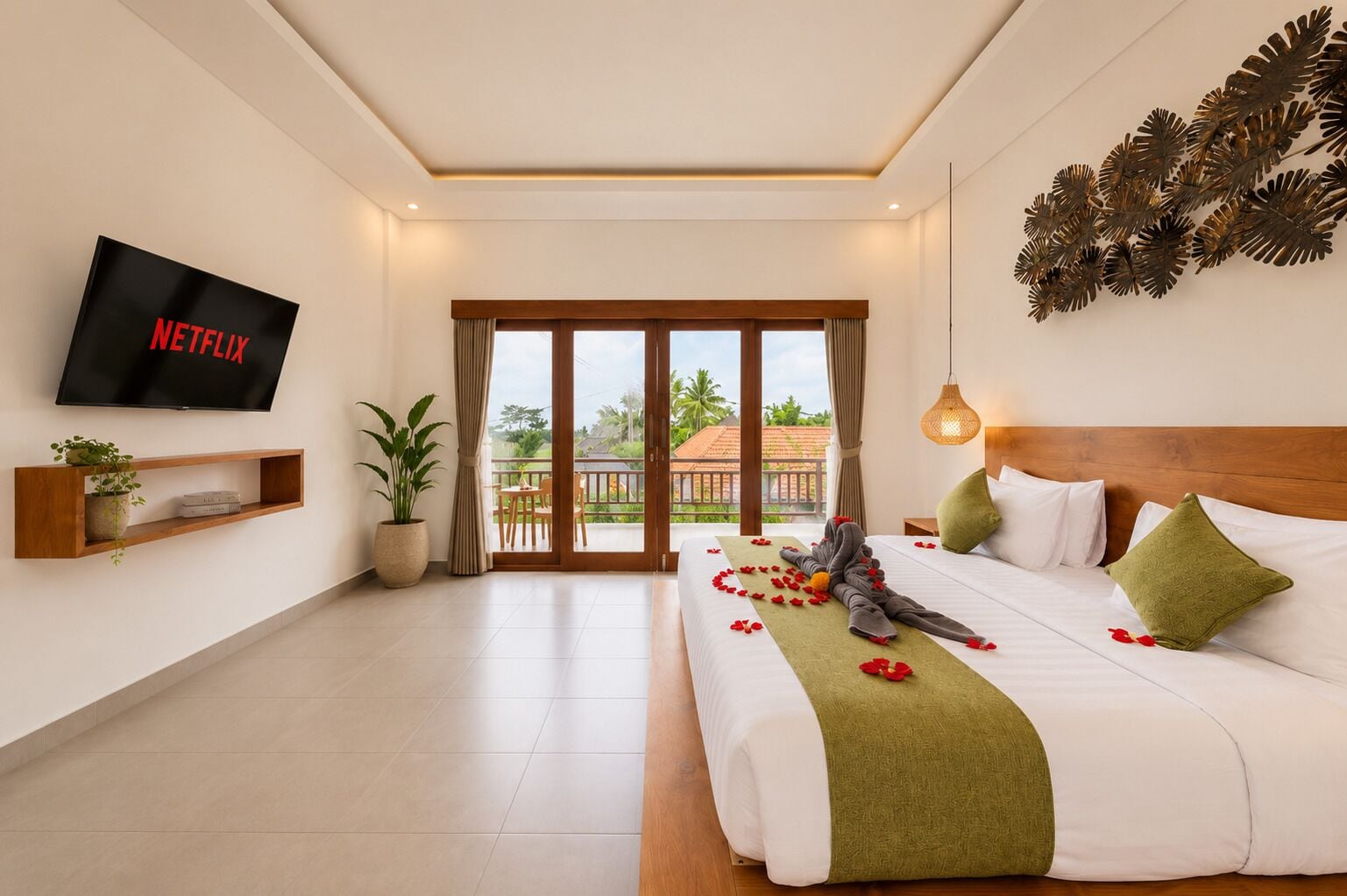 Habitación de hotel con cama, televisión, balcón y vistas al exterior.