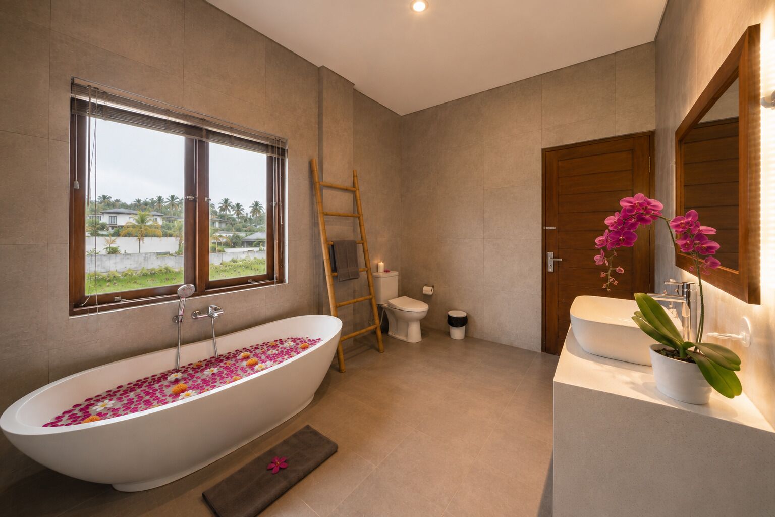 Un baño moderno con una bañera independiente, un inodoro y un lavamanos.