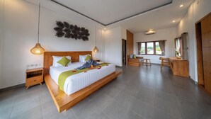 A modern bedroom with a large bed, bedside tables, a wooden bench, and a dining area with chairs. - Ada Private Villa Ubud (Ubud)